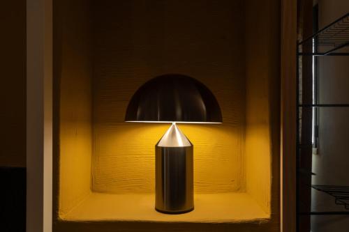 a light in a shelf with a black candle at Acquasale - Antica Dimora Cialledda in Polignano a Mare