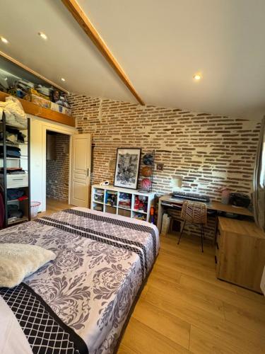 une chambre avec un lit et un mur de briques dans l'établissement Maison chaleureuse, à Rabastens