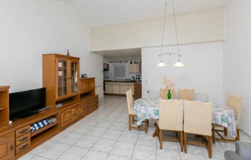 a kitchen and dining room with a table and a television at Apartments First row in Zavalatica