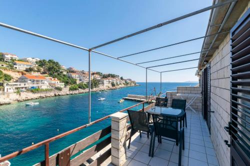 a balcony with a table and chairs overlooking the water at Apartments First row in Zavalatica