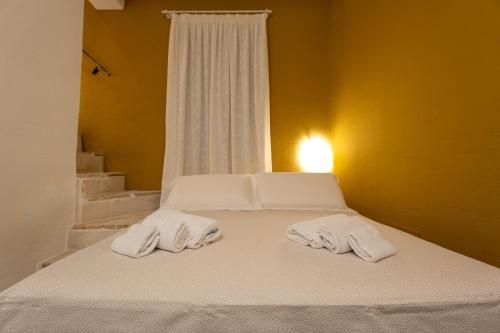 a bed with two towels on it with a window at Acquasale - Antica Dimora Cialledda in Polignano a Mare