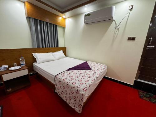 a small bedroom with a bed and a night stand at Hotel Star Plus Uttora in Bāiljuri