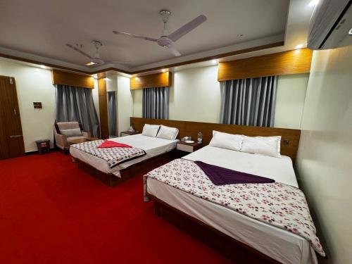 a hotel room with two beds and a chair at Hotel Star Plus Uttora in Bāiljuri