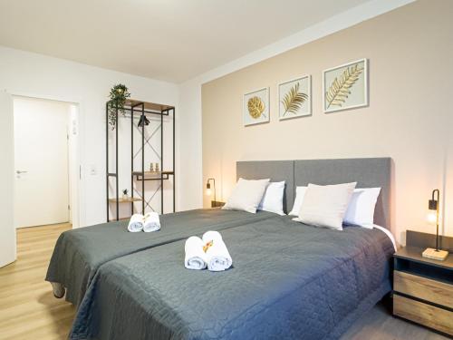 a bedroom with a large bed with two towels at ImmoStay- Neustadt Apartments, TV & WiFi in Bremen