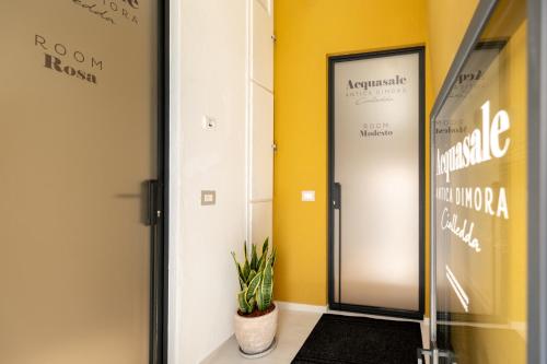 a hallway with a door and a plant at Acquasale - Antica Dimora Cialledda in Polignano a Mare