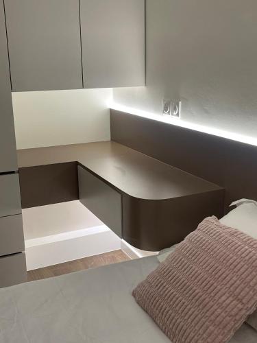 - une cuisine avec des placards blancs et un lit dans l'établissement Appartement Luxueux à 30min de la Tour Eiffel, à Asnières-sur-Seine