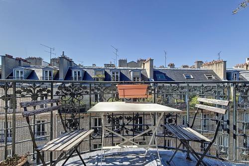- un balcon avec une table et deux chaises dans l'établissement Large family duplex near Parc Monceau, à Paris
