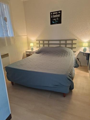 - un lit dans une chambre avec un panneau mural dans l'établissement le charme des dosses, au Barcarès