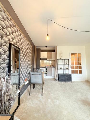 un salon avec une chaise et une cuisine dans l'établissement Biarritz Centre Jardin Public et Gare du Midi, à Biarritz