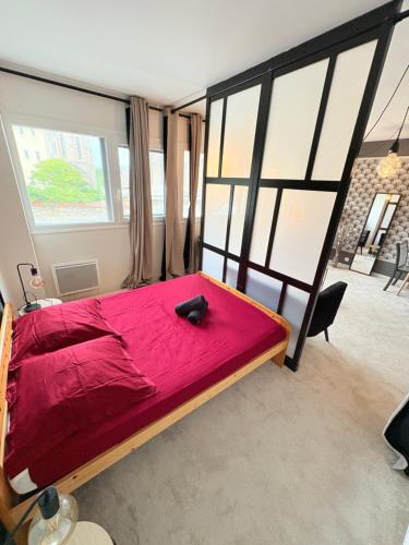 a large red bed in a room with large windows at Biarritz Centre Jardin Public et Gare du Midi in Biarritz
