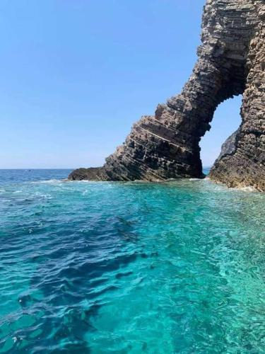 an arch in a rock formation in the ocean at RomaOlyaHouse in Budva