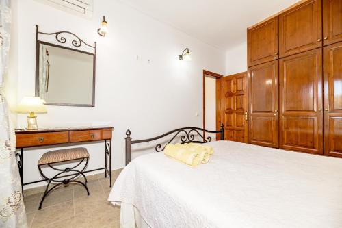 a bedroom with a bed and a desk and a mirror at Arazzo Apartments in Vasilikos