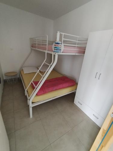 une chambre avec deux lits superposés dans une pièce dans l'établissement Maison de vacances à la plage, à Créances