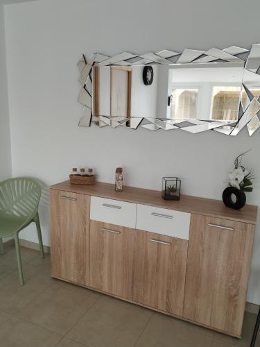 - un miroir au-dessus d'une commode en bois dans l'établissement Maison de vacances à la plage, à Créances