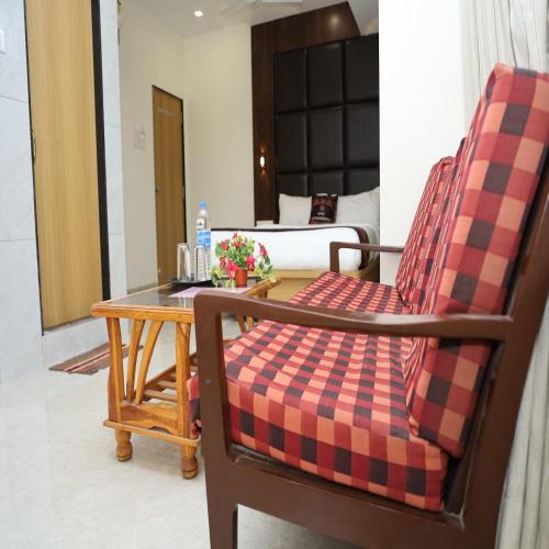 a room with a table and two chairs and a bed at Hotel Satyam Residency in Navi Mumbai