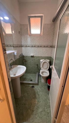 a bathroom with a toilet and a sink at Dhoma Plazhi Husi in Borsh