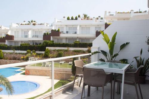 a balcony with a table and chairs and a swimming pool at Nova Beach Penthouse in Gran Alacant