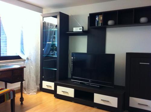 a black entertainment center with a flat screen tv at Ulrikesferienwohnung2 in Homburg