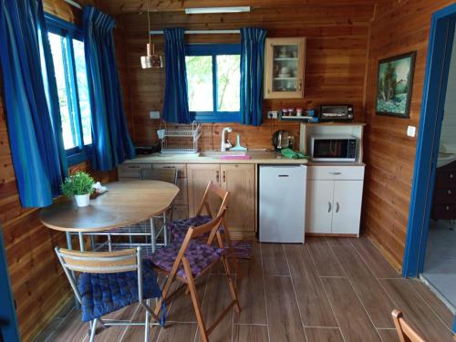 a kitchen with a table and chairs in a cabin at In our backyard - Metula in Metulla
