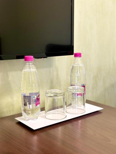 two bottles and two glasses sitting on a napkin at VLG Hotel in Boryspilʼ