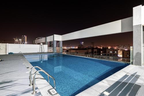 a swimming pool on the roof of a building at night at New 1BR with Full Balcony Gym Pool and Sauna in Dubai