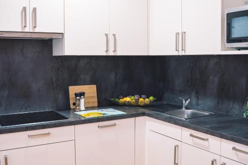 a kitchen with white cabinets and a sink at Hotel Restaurant Thadeushof in Techelsberg am Worthersee