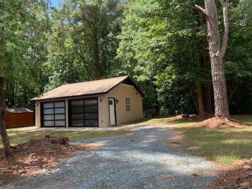 チャペルヒルにあるChapel Hill Guest house retreatの森の中にあるガレージ付きの小さな建物