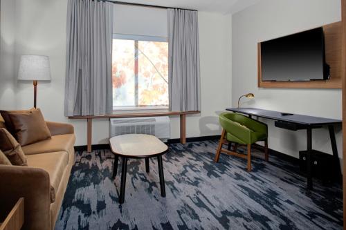 a living room with a couch and a desk in a room at Fairfield by Marriott Inn & Suites Beckley in Beckley