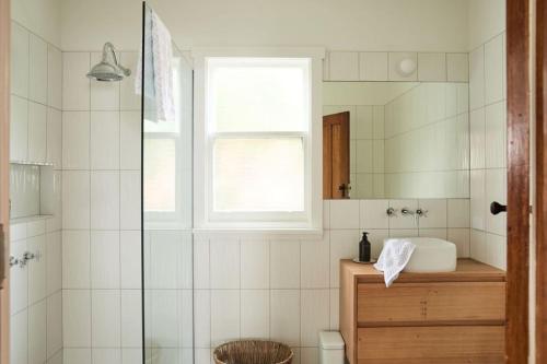 une salle de bain avec douche et lavabo dans l'établissement Mid-Century Modern Retreat, à Kings Park