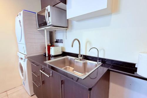 a kitchen with a sink and a microwave at Seaview White 1Br Balcony in Manama