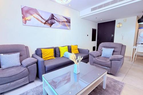 a living room with two couches and a table at Seaview White 1Br Balcony in Manama