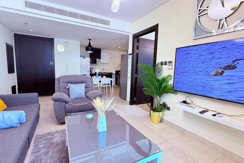 a living room with a large flat screen tv at Seaview White 1Br Balcony in Manama