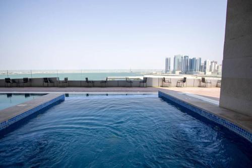 a swimming pool with a view of the ocean at Seaview White 1Br Balcony in Manama