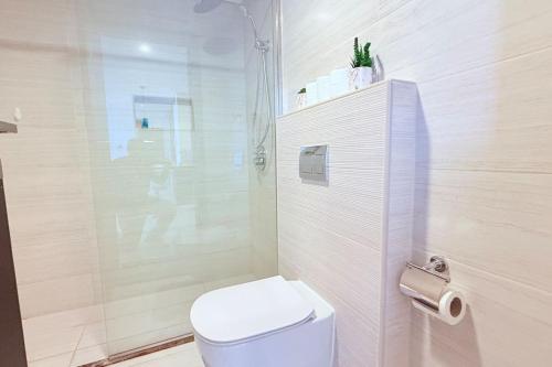 マナーマにあるPenthouse 75 inch TV Sea Viewのトイレとシャワー付きの白いバスルーム