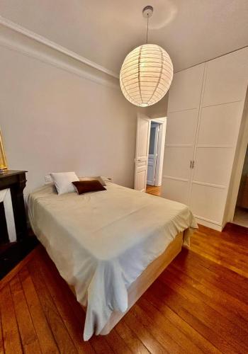 une chambre avec un grand lit et un lustre dans l'établissement Parisian nest, à Paris