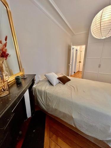 une chambre avec un grand lit et un miroir dans l'établissement Parisian nest, à Paris