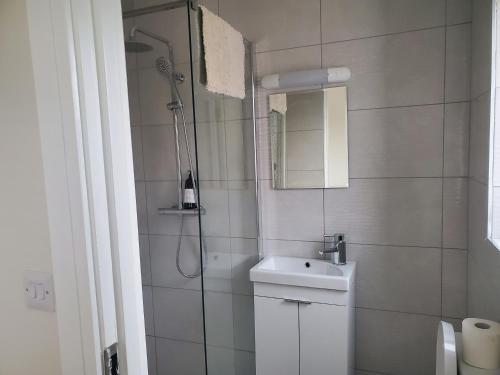 a white bathroom with a shower and a sink at Seaside Retreat-2 Bed-Sleeps 4-Parking-Pets in Portmagee