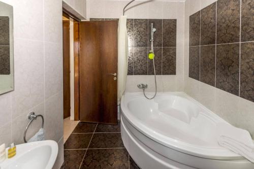 a bathroom with a tub and a toilet and a sink at Villa Cypria Maria by Villa Plus in Peyia