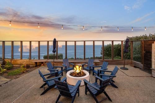 a patio with chairs and a fire pit with a view of the ocean at Entire Oceanfront Home Breathtaking 180 Views Near San Francisco in Montara