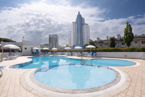 a large swimming pool with chairs and umbrellas at ANIMA JESOLO - DRAGO VILLAGE, Beach & Pool, 2 Parkings in Lido di Jesolo