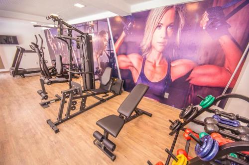 ein Fitnessstudio mit mehreren Laufbändern und einem Gemälde einer Frau in der Unterkunft BelaVista Flats - Gold Flat in João Pessoa