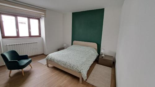 Un pequeño dormitorio con una cama y una silla. en Appartamento Via Mazzini Gubbio Centro, en Gubbio