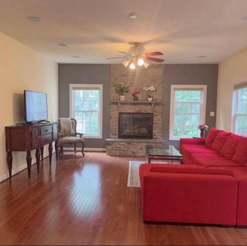 a living room with a red couch and a fireplace at Luxury Villa in Springfield VA in Springfield