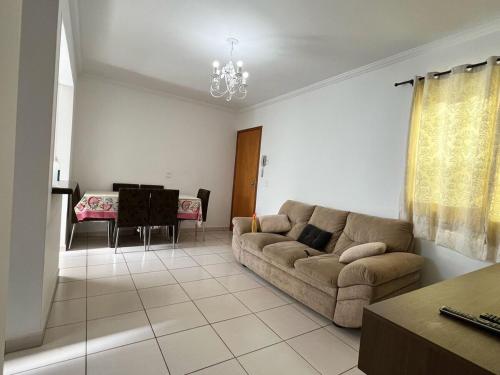 a living room with a couch and a table at Apartamento aconchegante com ótima localização! in Brotas