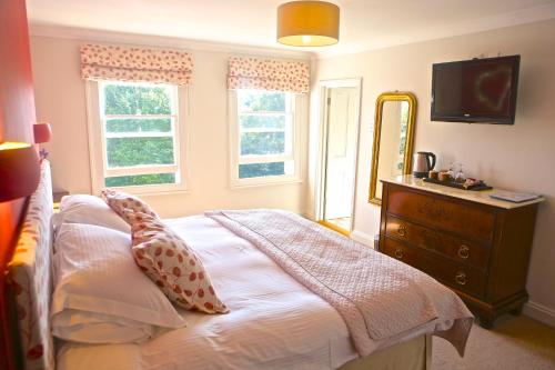 a bedroom with a bed with a dresser and a mirror at The Art House Hove in Brighton & Hove