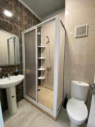 a bathroom with a shower and a toilet and a sink at Luxury sea view apt tanger with Swimming pool in Tangier