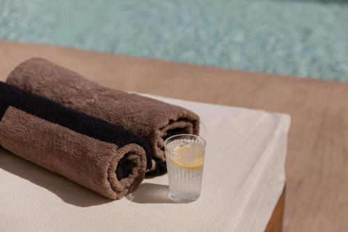 a towel and a glass of water sitting on a table at Sarana Suites Crete in Kissamos