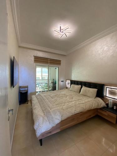 a bedroom with a large bed and a chandelier at Luxury sea view apt tanger with Swimming pool in Tangier
