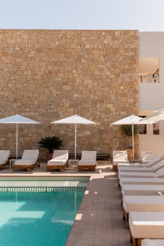 a swimming pool with lounge chairs and umbrellas at Sarana Suites Crete in Kissamos