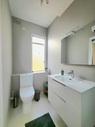 a bathroom with a toilet and a sink and a window at Marina View in Taʼ Xbiex